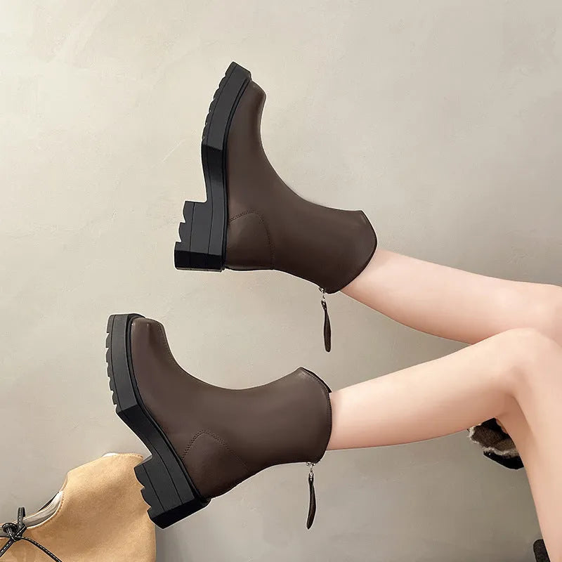 Black women's platform Martin boots with a square toe and back zipper on a wooden floor.
