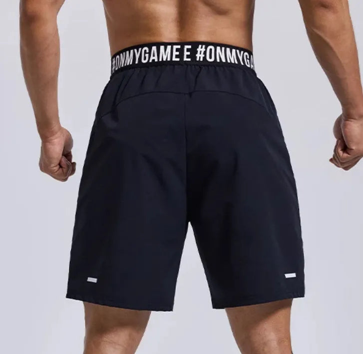 Men's loose cropped sports shorts in black with elastic waist and letter detail.