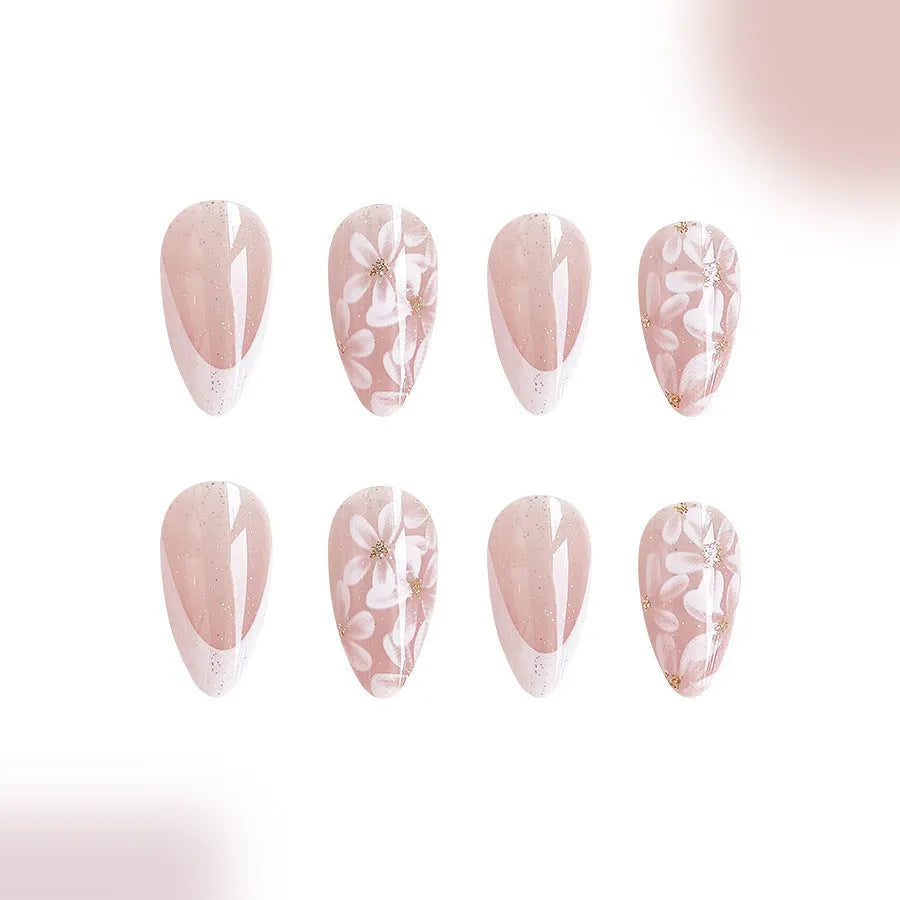 Short almond-shaped false nails with French style tips and glittering pink powder flowers on a white background.