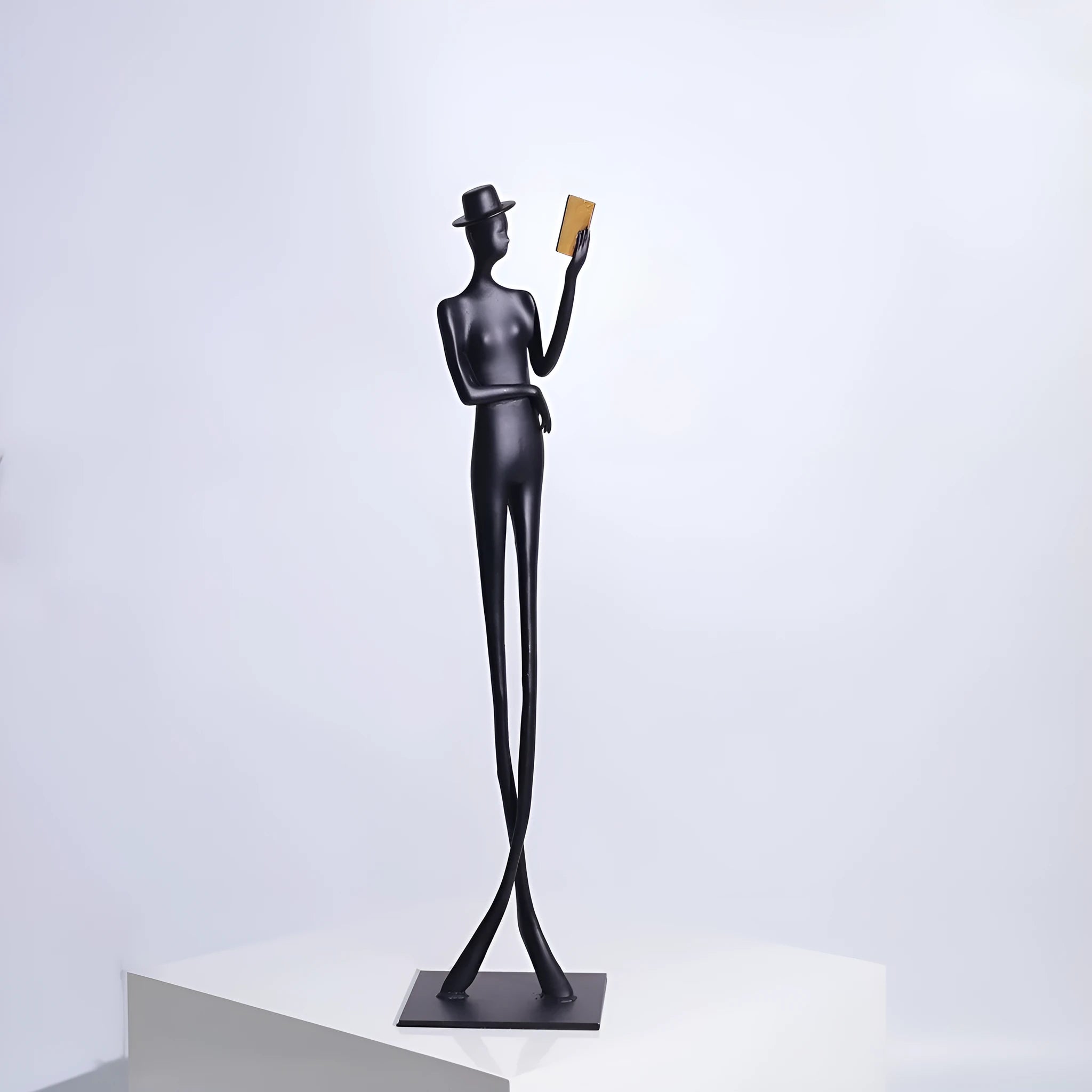 Black aluminium reading woman desk sculpture measuring 12cm by 12cm by 51cm