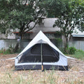 Brown or white A-frame pole-free cabin tent erected with hiking cane supports