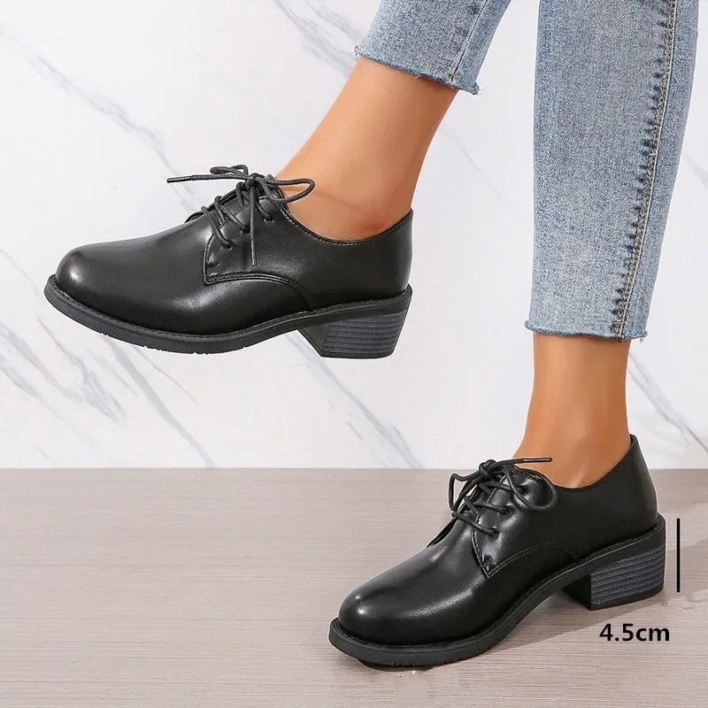 Black women's low-top work shoes with a chunky rubber heel and pointed toe.