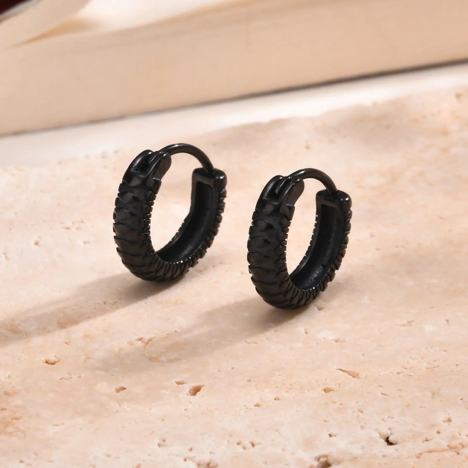 Stainless steel ear ring with a geometric snake pattern in a black finish.