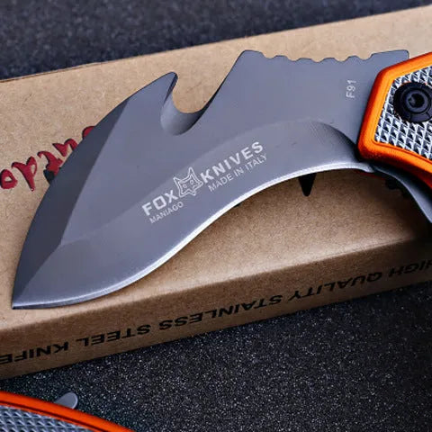 Orange folding knife with steel handle and 8.2cm blade open on outdoor surface showing total length and grip texture