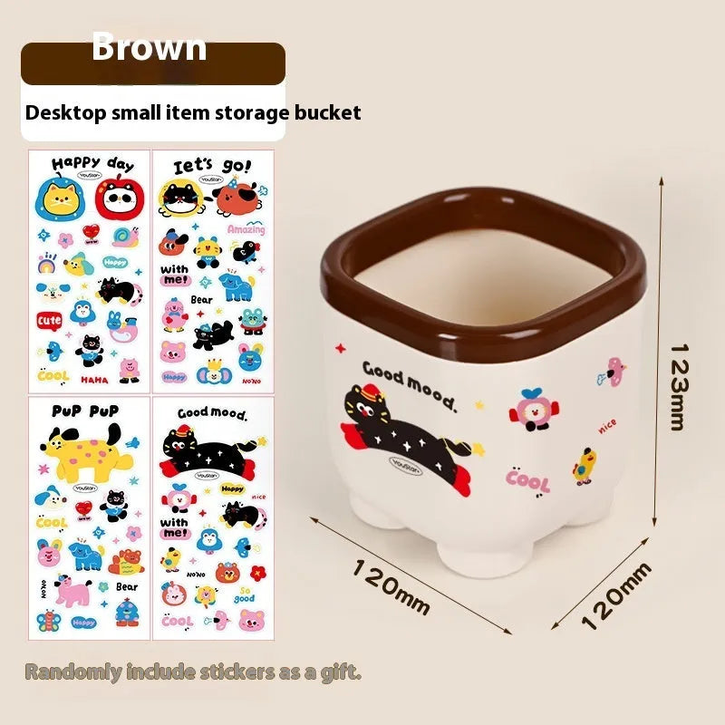 Red and brown cartoon sticker designs on a plastic desktop storage box with grid organiser compartments.