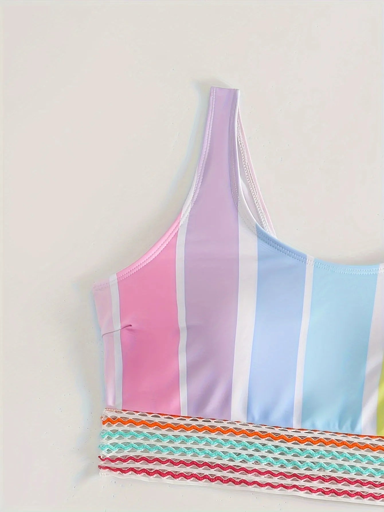 Women's striped two-piece bikini set for swimming and sports on a neutral background.