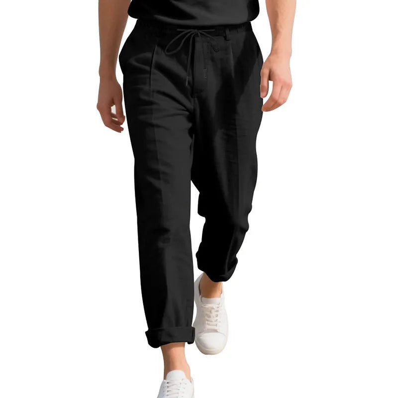 Man wearing light khaki linen casual trousers with a drawstring waist and straight leg.