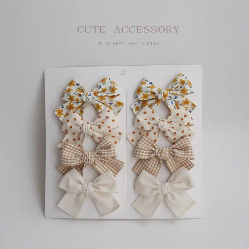 Set of children's fabric hairclips with dovetail bows in eight different colours and patterns.