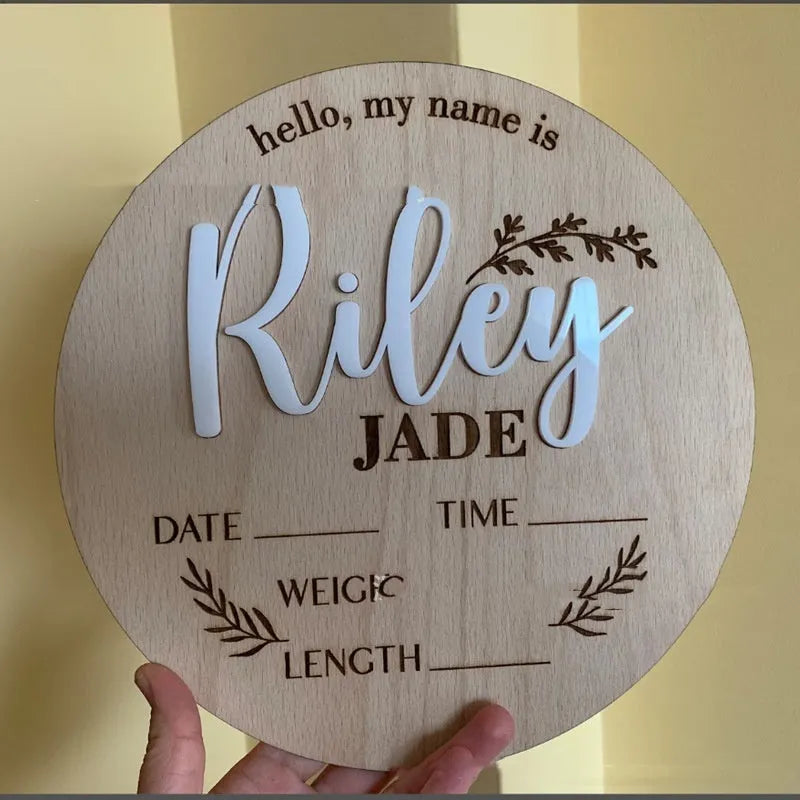 Square wooden baby name sign with birth information, 15 cm wide, in one of three style variants.