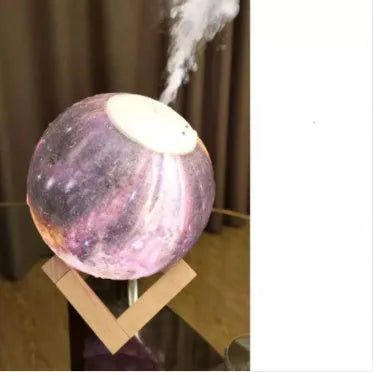 Spherical moon humidifier with LED night light on a bedside table, showing USB charging cable