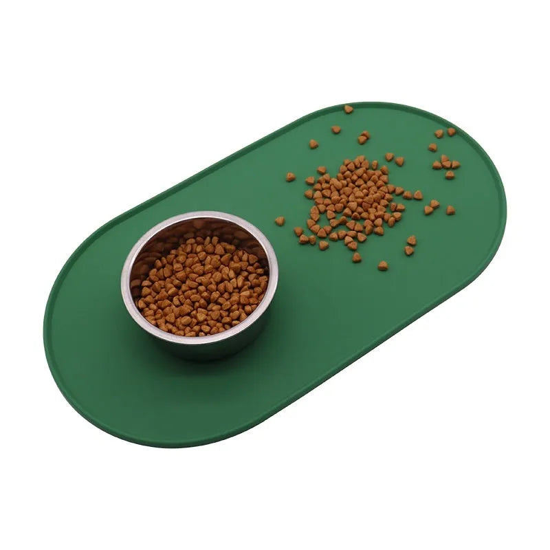Green silicone cat feeding placemat with a food bowl on it, showing its waterproof, wipe-clean surface.