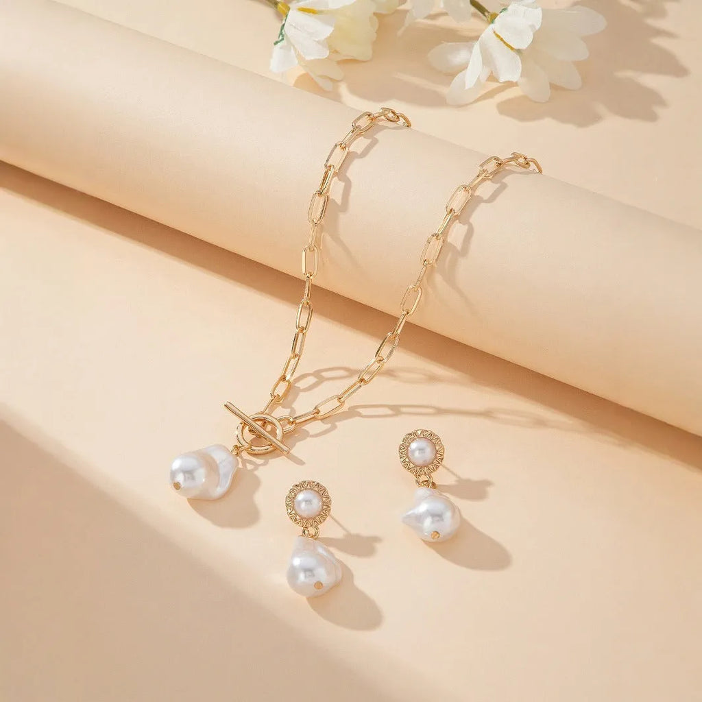 Gold-colour baroque pearl necklace and stud earrings jewellery set on display