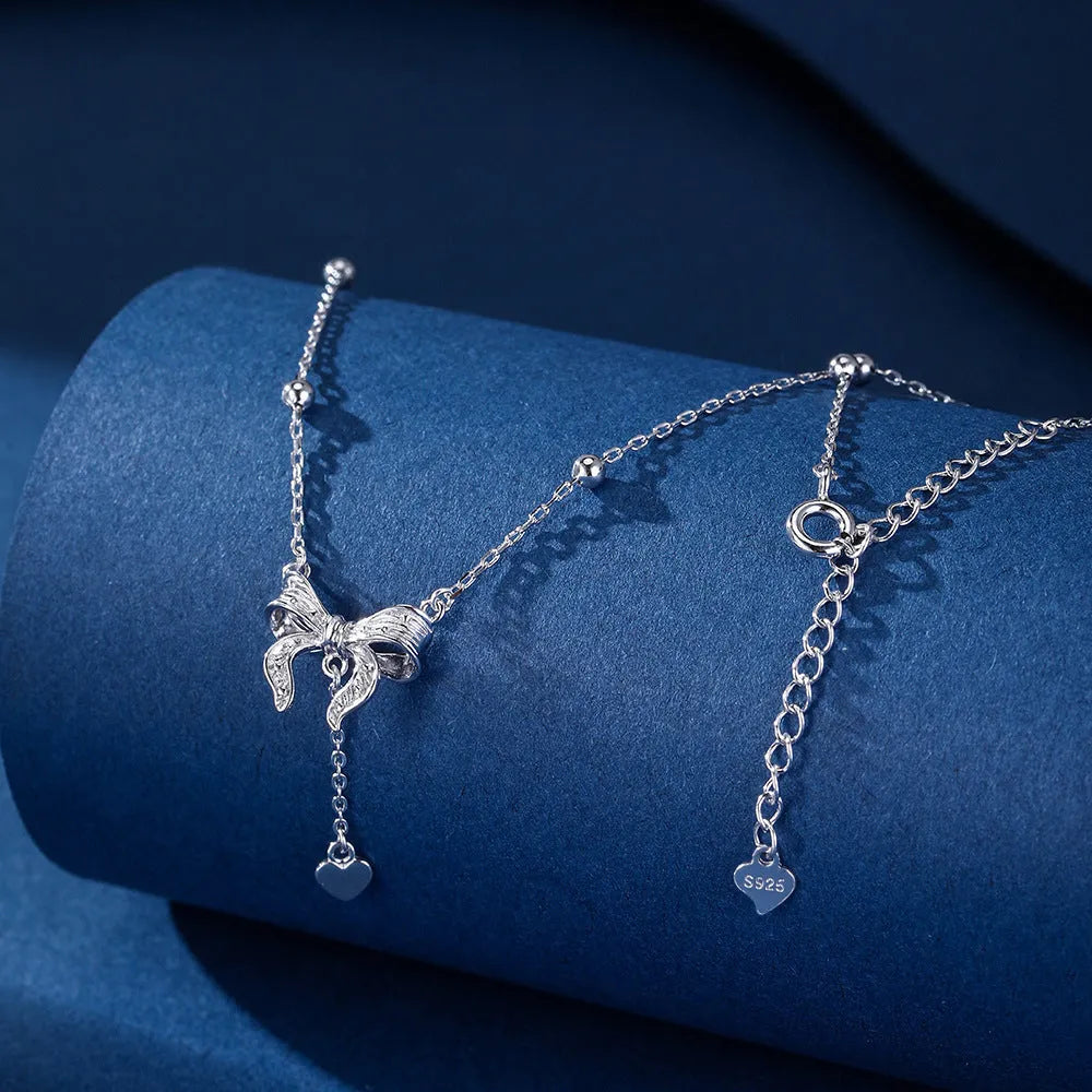 Close-up of a silver heart pendant necklace with butterfly detail on a 40-45cm O-ring chain.
