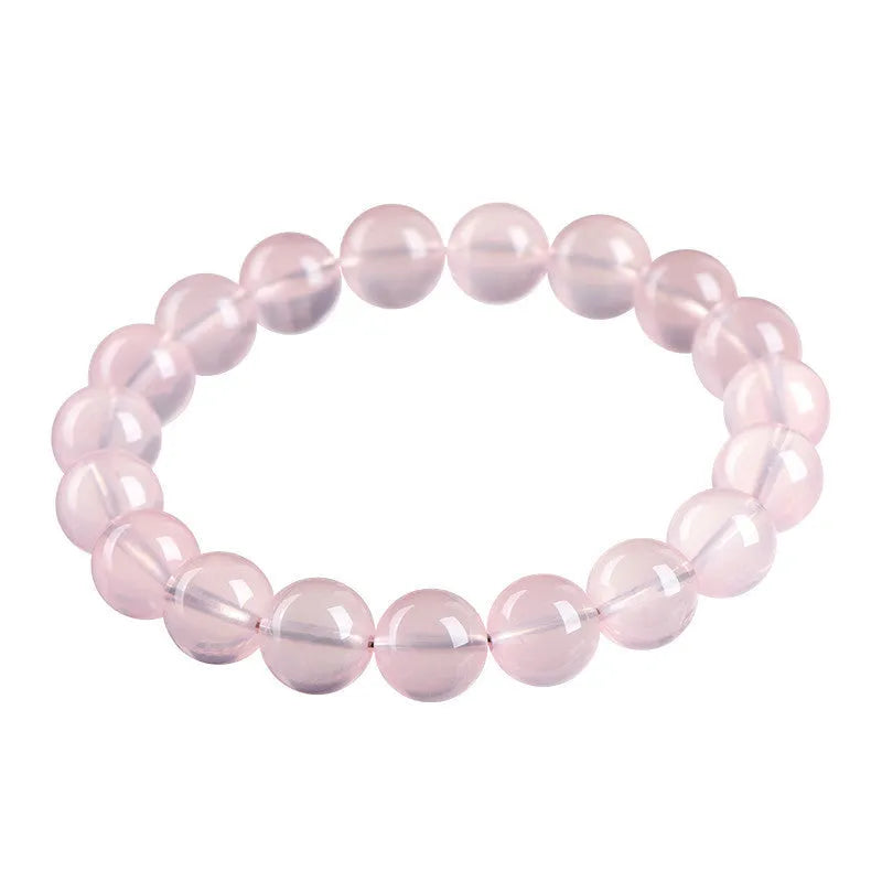 A polished natural starlight crystal bead bracelet in pink, shown as a single circle.