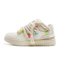 Creamy white Old Damage retro skate shoes with lace-up front, low-top platform heel, and rubber sole.