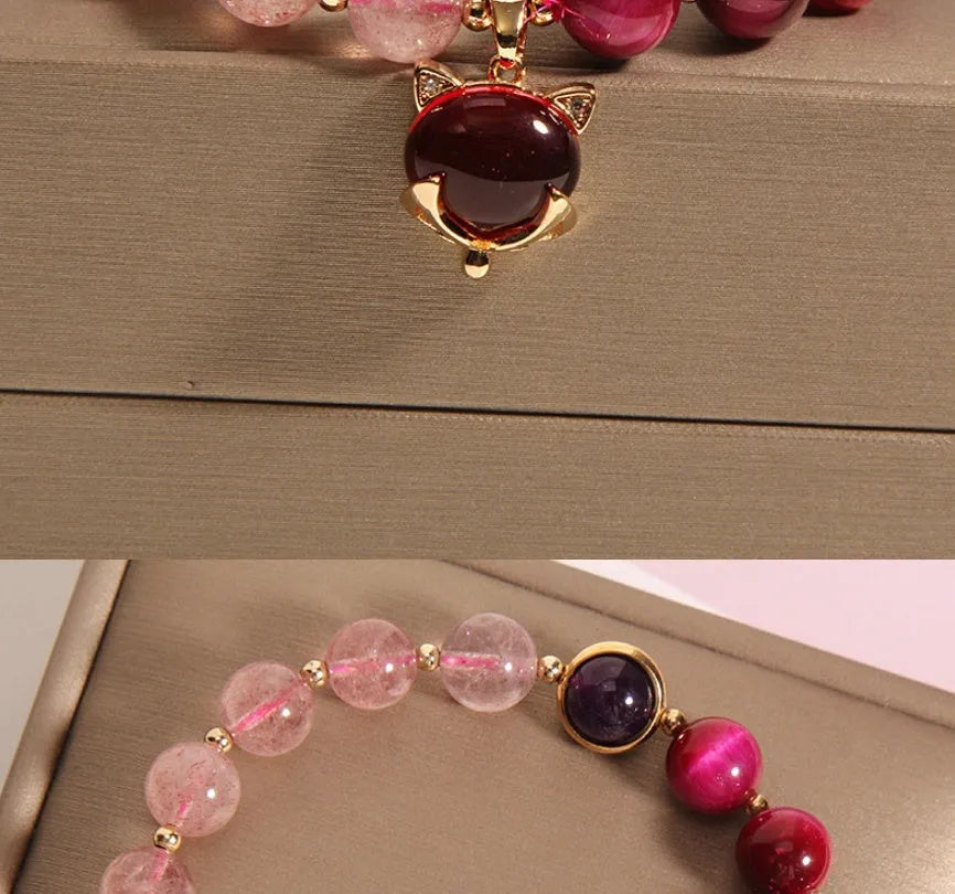 Simple bracelet with a red strawberry crystal on a black elastic rope.