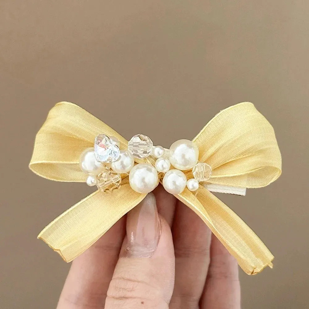 Yellow bow barrette with rhinestone and pearl on duckbill clip for women