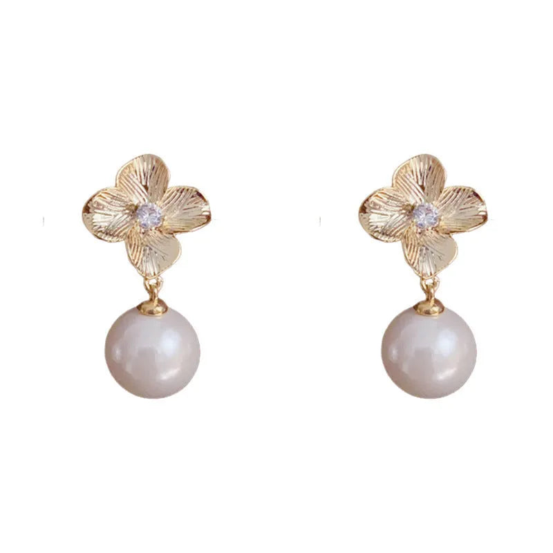 Pair of gold-plated copper earrings with metal petal design and faux pearl accents for women