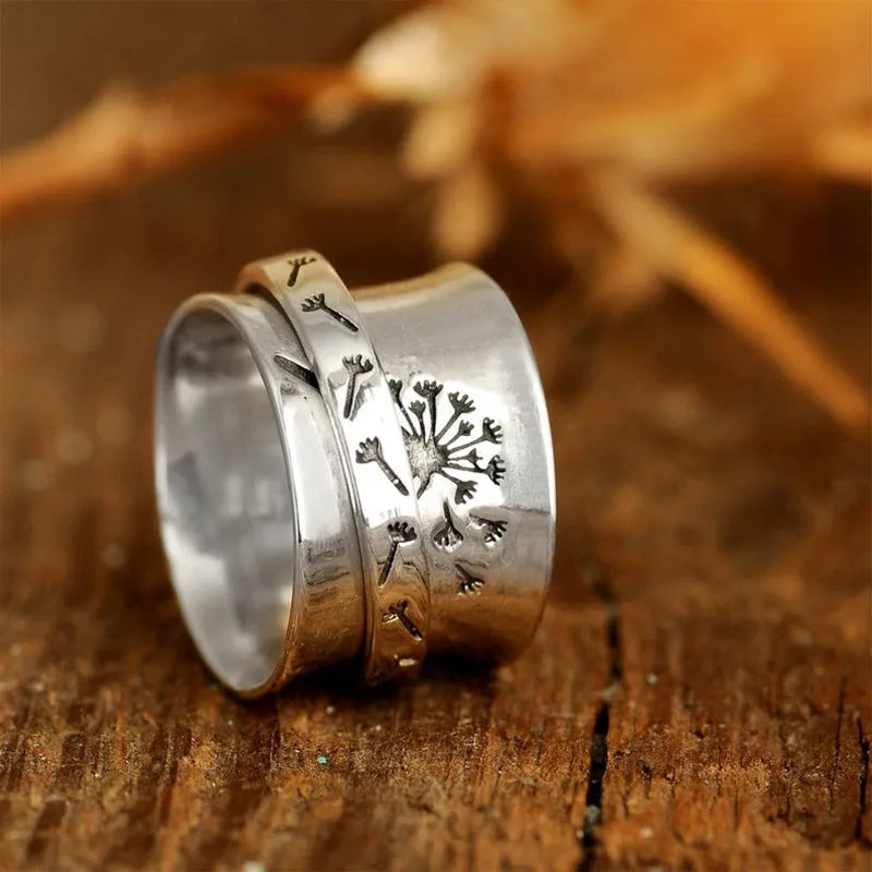 Silver rotatable floral fashion ring showing adjustable flower element on band