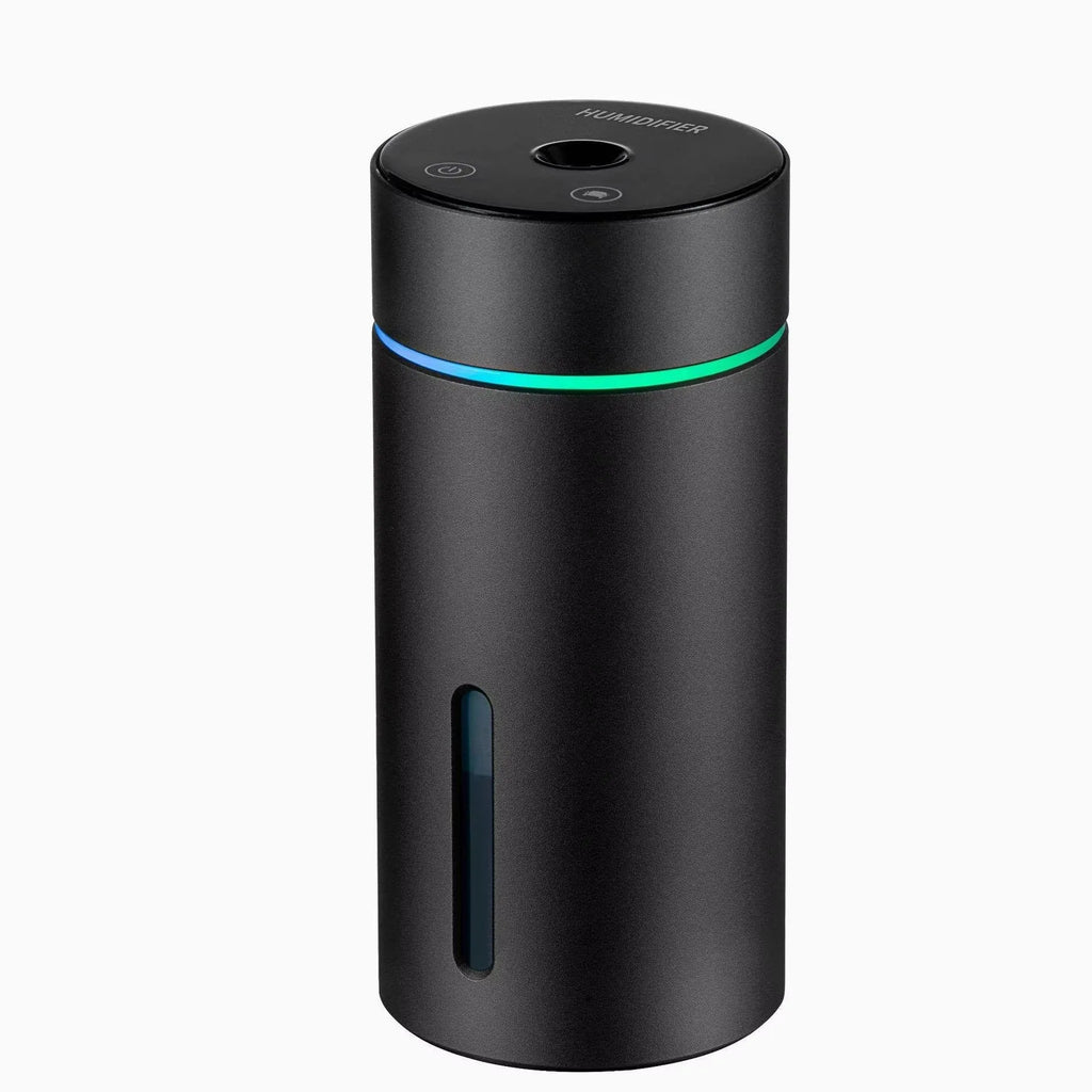 Black aluminium car humidifier and essential oil diffuser with night light on a desk next to USB cable.