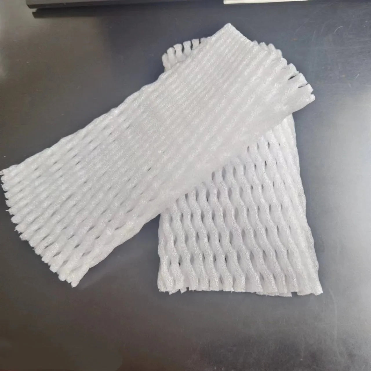 White foam net cover for fruit protection shown in various sizes on a table.