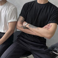 Men's slim fit cotton T-shirt in black on a hanger, showing round neck and half-sleeve design.
