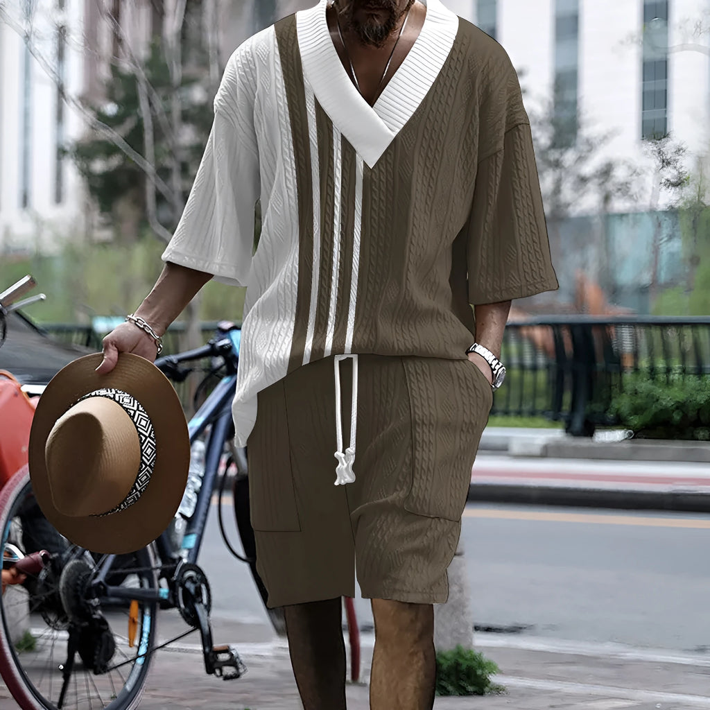 Man wearing a grey printed knitted short-sleeved top with drop shoulders and matching shorts, a casual two-piece suit set.