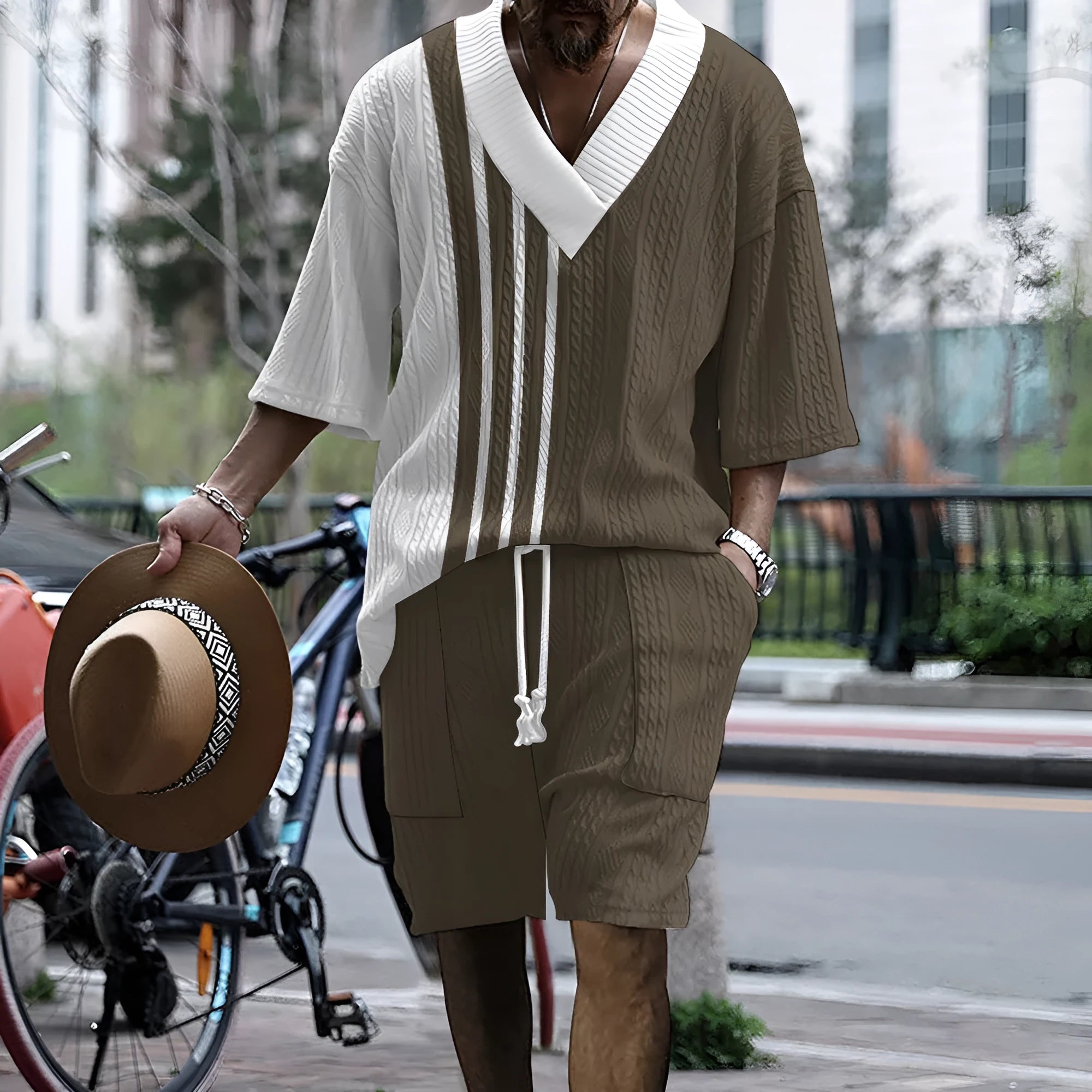Man wearing a grey printed knitted short-sleeved top with drop shoulders and matching shorts, a casual two-piece suit set.