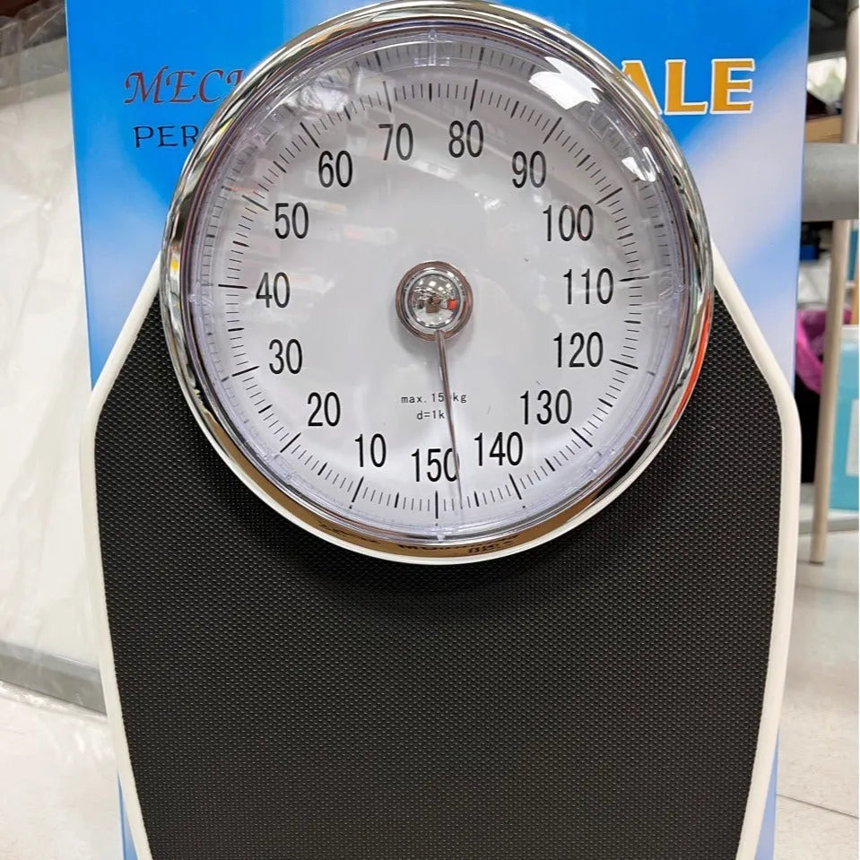 Black mechanical body weight scale with large dial on a simple platform