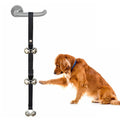 Silver metal dog training bells on an adjustable nylon leash hanging from a door handle