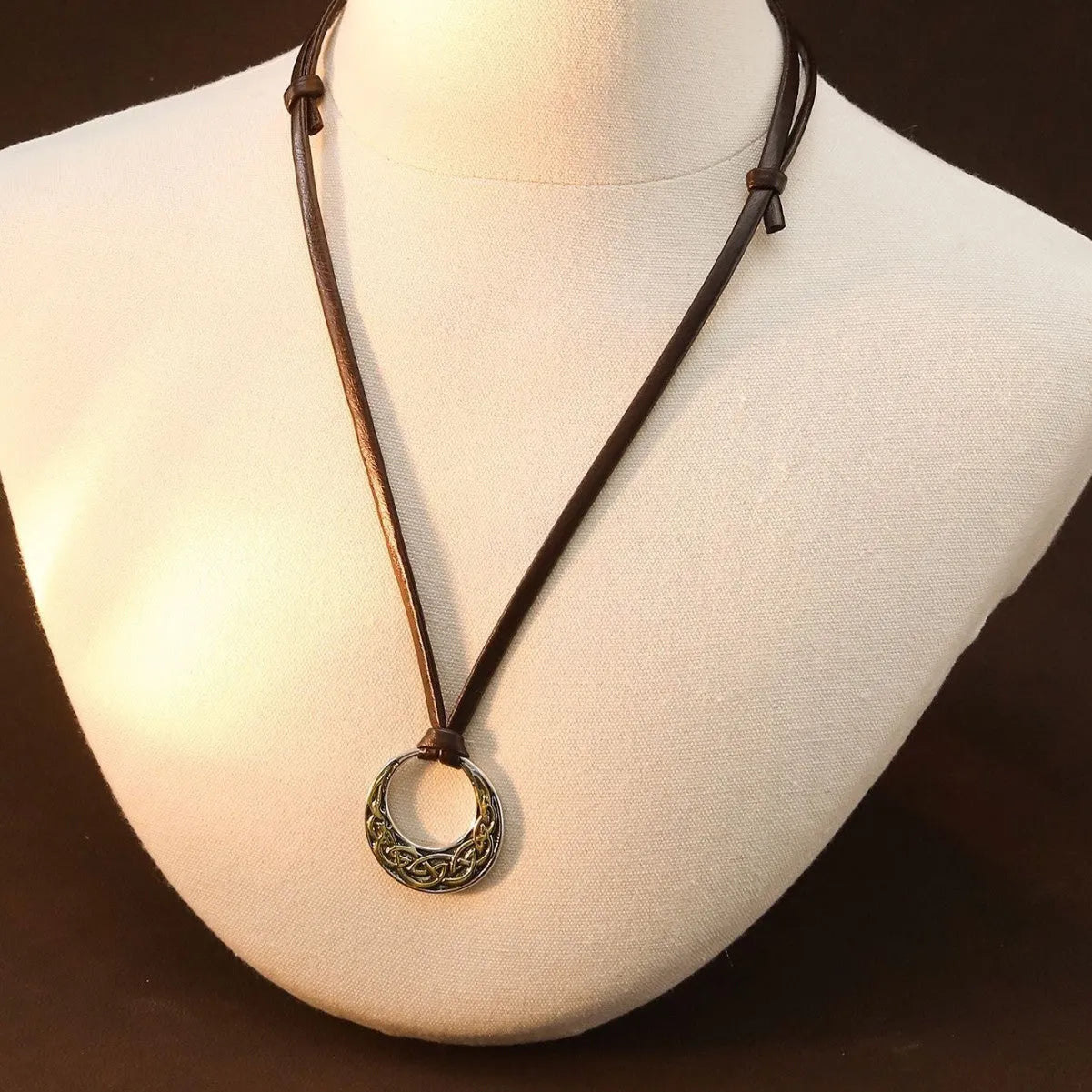 Alloy skull pendant necklace with adjustable knot chain in antique silver on a neutral background