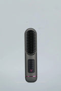 White portable negative ion hair comb with rechargeable battery on a plain background.