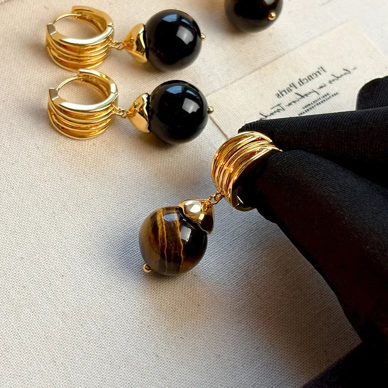 A pair of Fashion Maillard Tigereye earrings with a geometric shape and real gold plating, shown in brown and black colour options.