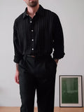 Black pinstriped polyester button-down shirt with regular fit on hanger