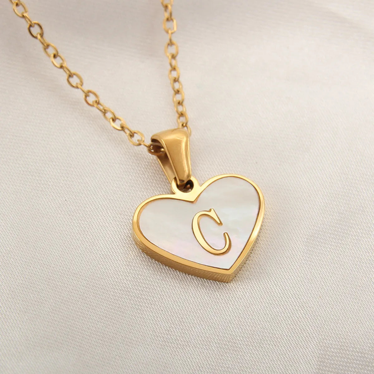 Gold heart necklace with white shell pendant and initial charm on 45cm adjustable chain