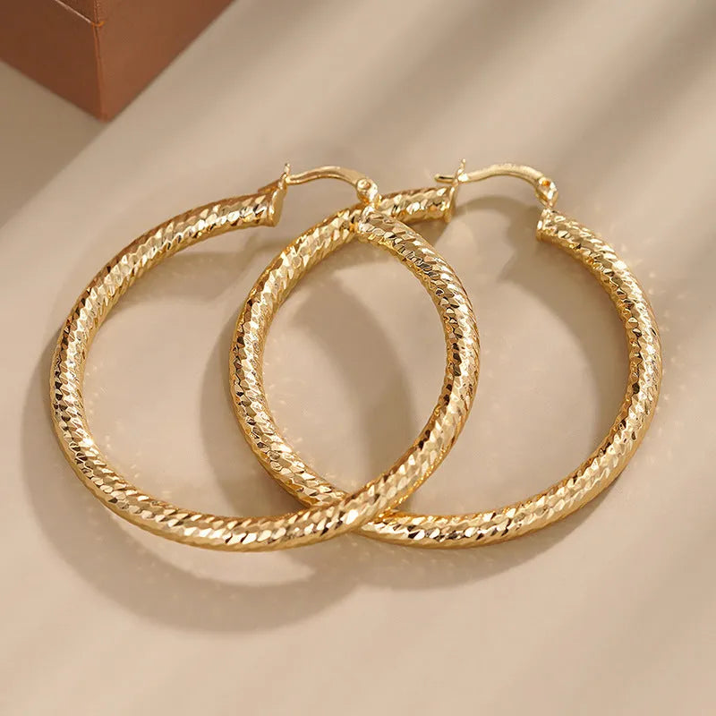 Women's geometric ring design copper clip-on earrings in electroplated colours on a white background.