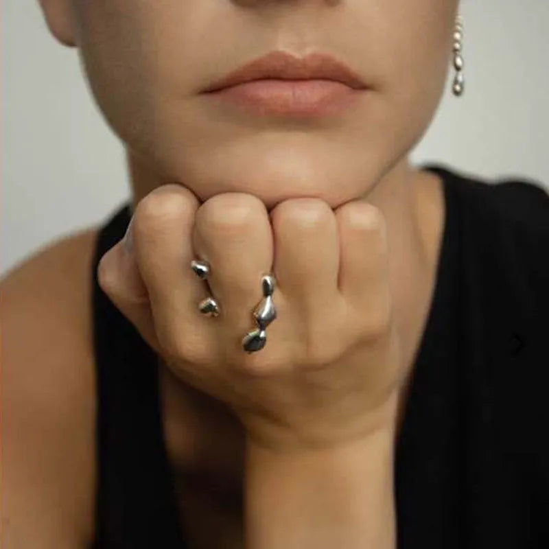Open circle brass fashion ring with spherical beads in gold tone on a hand.