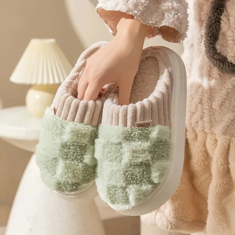 Women's plaid patterned plush slippers with non-slip sole in multiple colours on a wooden floor.