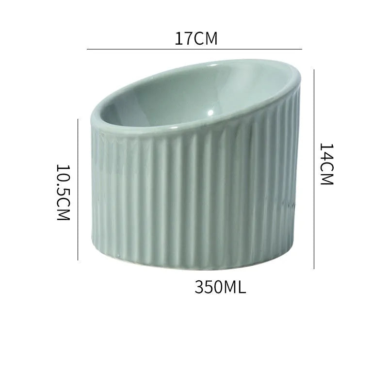 A dark green ceramic elevated cat bowl with a tilted, round design on a wooden surface.
