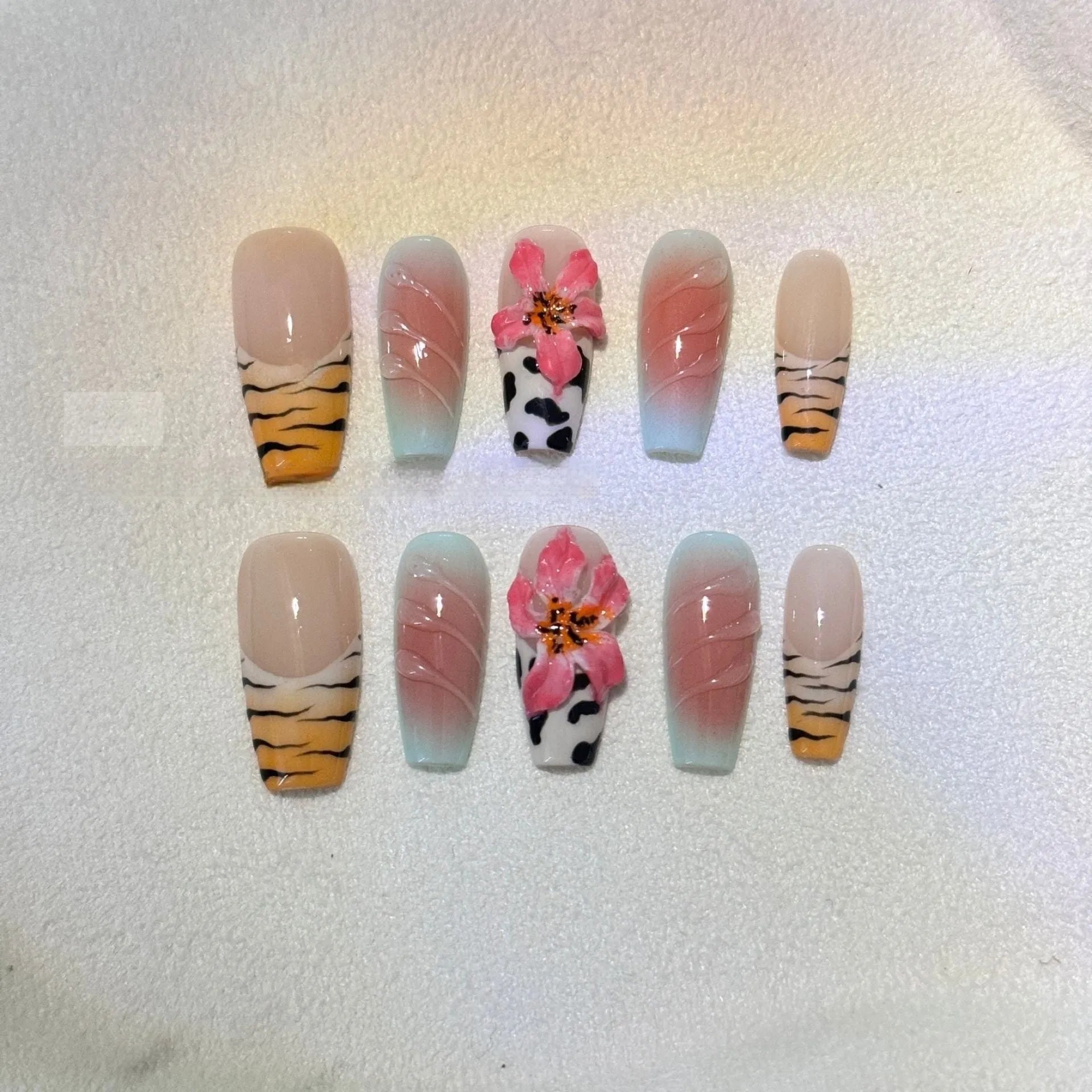 Embossed lily flower and leopard print zebra pattern nail art set showing dimensional texture and size variations