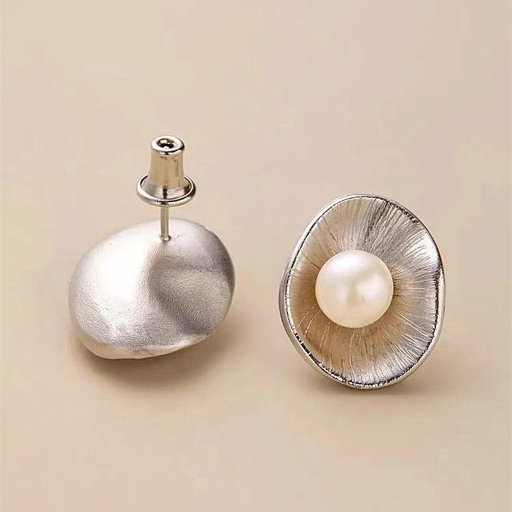 Pearl sterling silver needle earrings with geometric design elements in gold colour