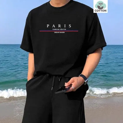 Man wearing a loose fit apricot coloured short-sleeved T-shirt with a black letter print on the front.