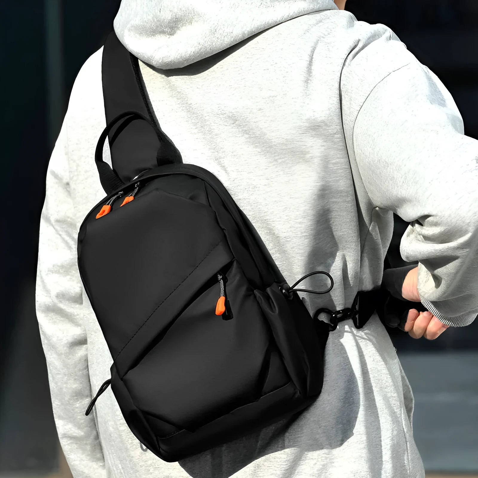 Men's black polyester crossbody bag with single shoulder strap shown in casual setting