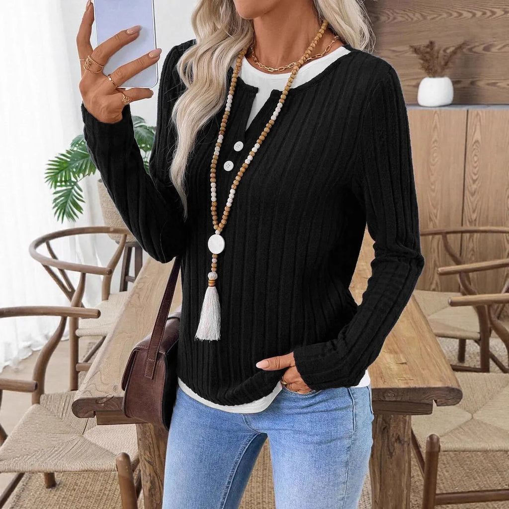 Women's black fake two-piece round neck button pullover sweater with long sleeves on a hanger.