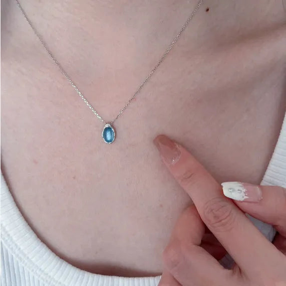 Geometric navy blue and platinum colour water drop pendant necklace on a cross chain.