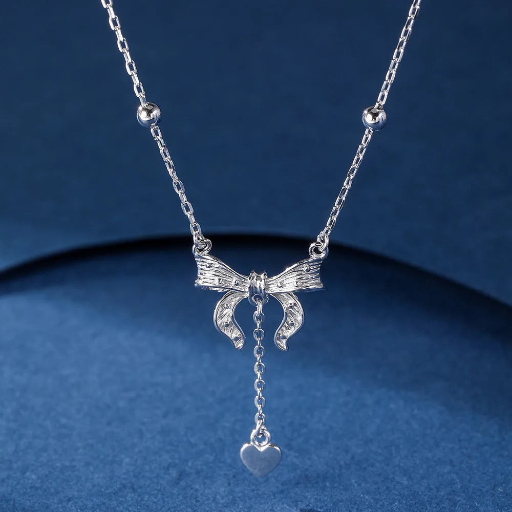 Close-up of a silver heart pendant necklace with butterfly detail on a 40-45cm O-ring chain.
