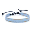 Handmade denim fabric bracelet carrying strap in national style on wrist, showing charm attachment point.