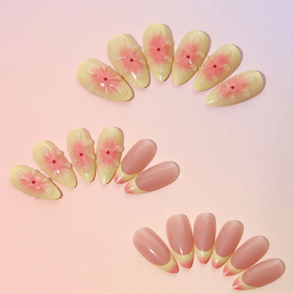 Fake nails set with white plastic armour pieces featuring raised pink and green cartoon flower designs.