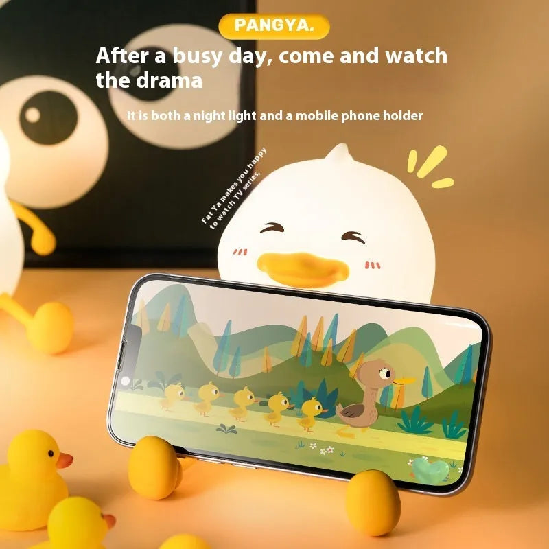 Chubby silicone desktop night light with phone holder showing soft LED illumination