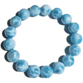 Blue Bodhi bead bracelet with a natural crystal sea-pattern stone charm on a wrist.